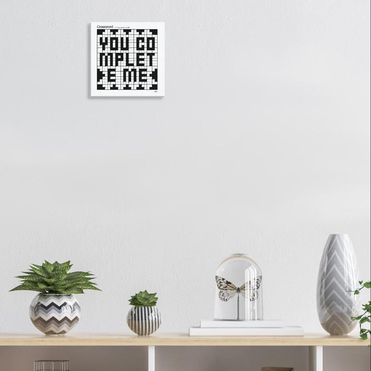 A white canvas with a crossword themed graphic that reads YOU COMPLETE ME hangs in a living room.