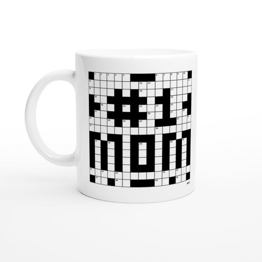 A white coffee or tea mug with a crossword themed graphic that reads #1 MOM sits on a coffee table.