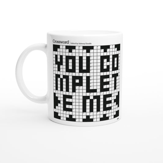 A white mug with a crossword puzzle graphic that reads YOU COMPLETE ME.